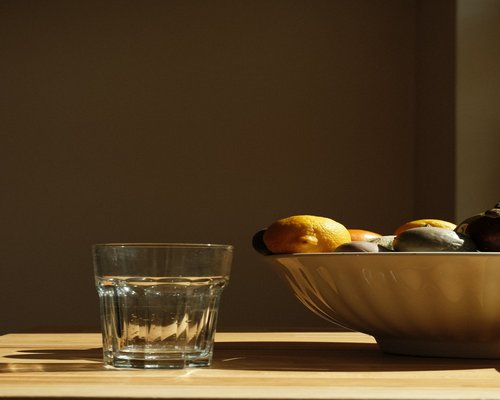 Fresh fruits, vegetables, and a glass of water on a table